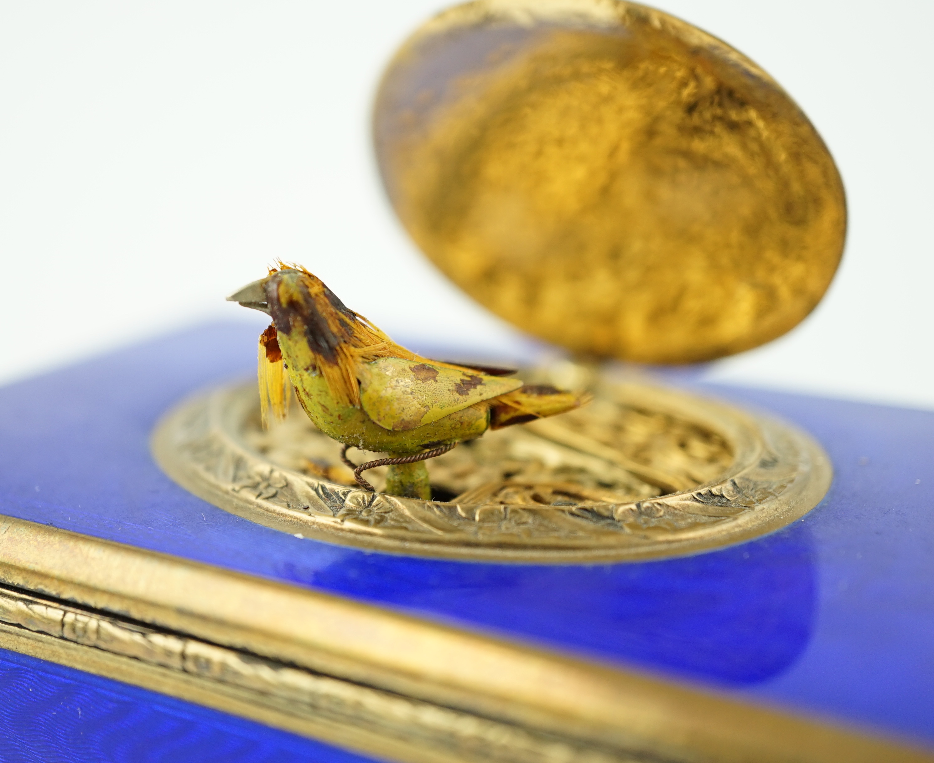 An early 20th century sterling silver gilt and blue guilloche enamelled rectangular singing bird box